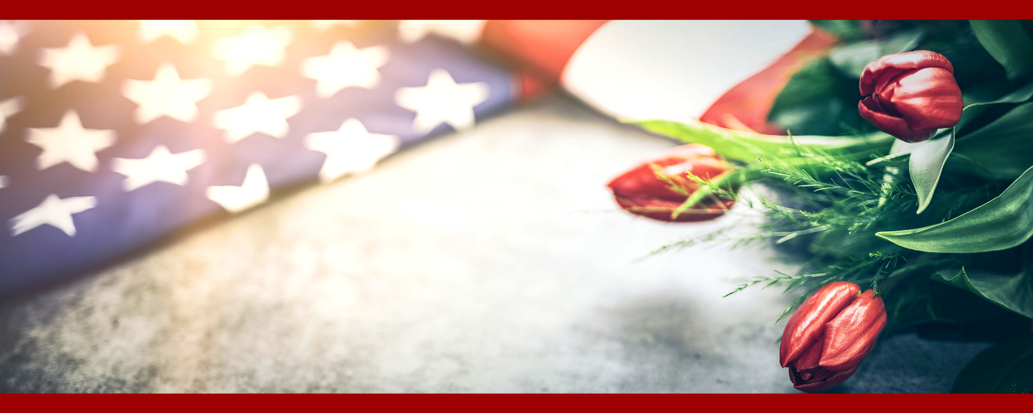 photograph of an American flag and red tulips
