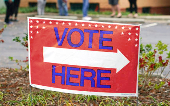 Voting sign reading vote here