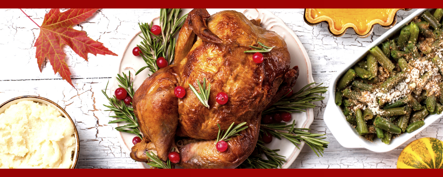 photograph of a dinner table from above with a roast turkey, mashed potatoes, and green beans