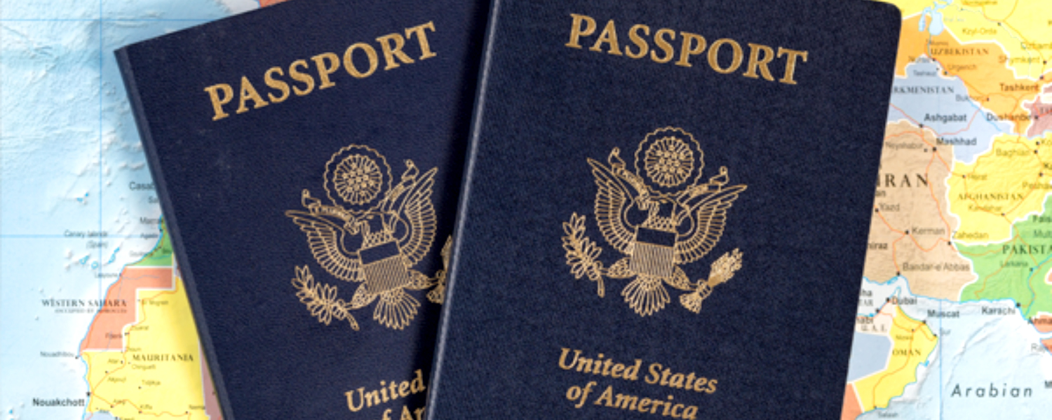 two US Passports sitting on top of a world map