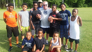 Group photo of kids with officer playing sports