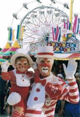 A photo of a clown and midway from the Yaraab Shrine Circus.