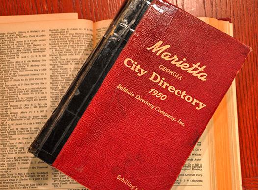 large red book titled "Marietta Directory" sitting on an open telephone directory