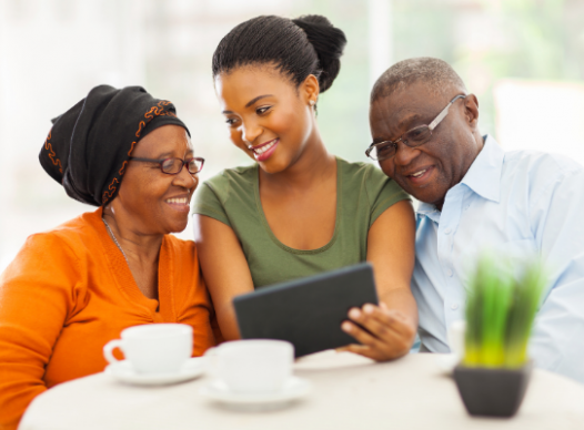 an adult showing two older adults a tablet