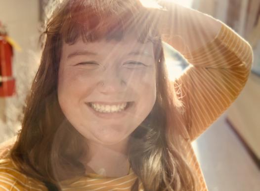 KC (woman) smiling with sunrays behind her.