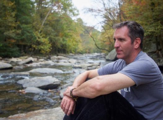 Man sitting looking out at river