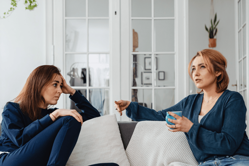 deux amies discutent sur le canapé dans le salon