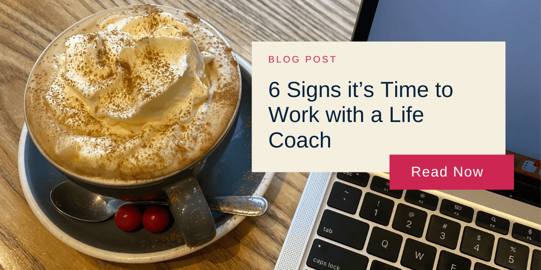 Blog post image showing a cappuccino with whipped cream and a laptop on a wooden table. Overlay text reads "6 Signs it’s Time to Work with a Life Coach."