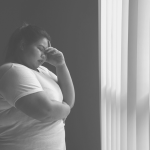 A Filipina covering her face with her hand because of shame.