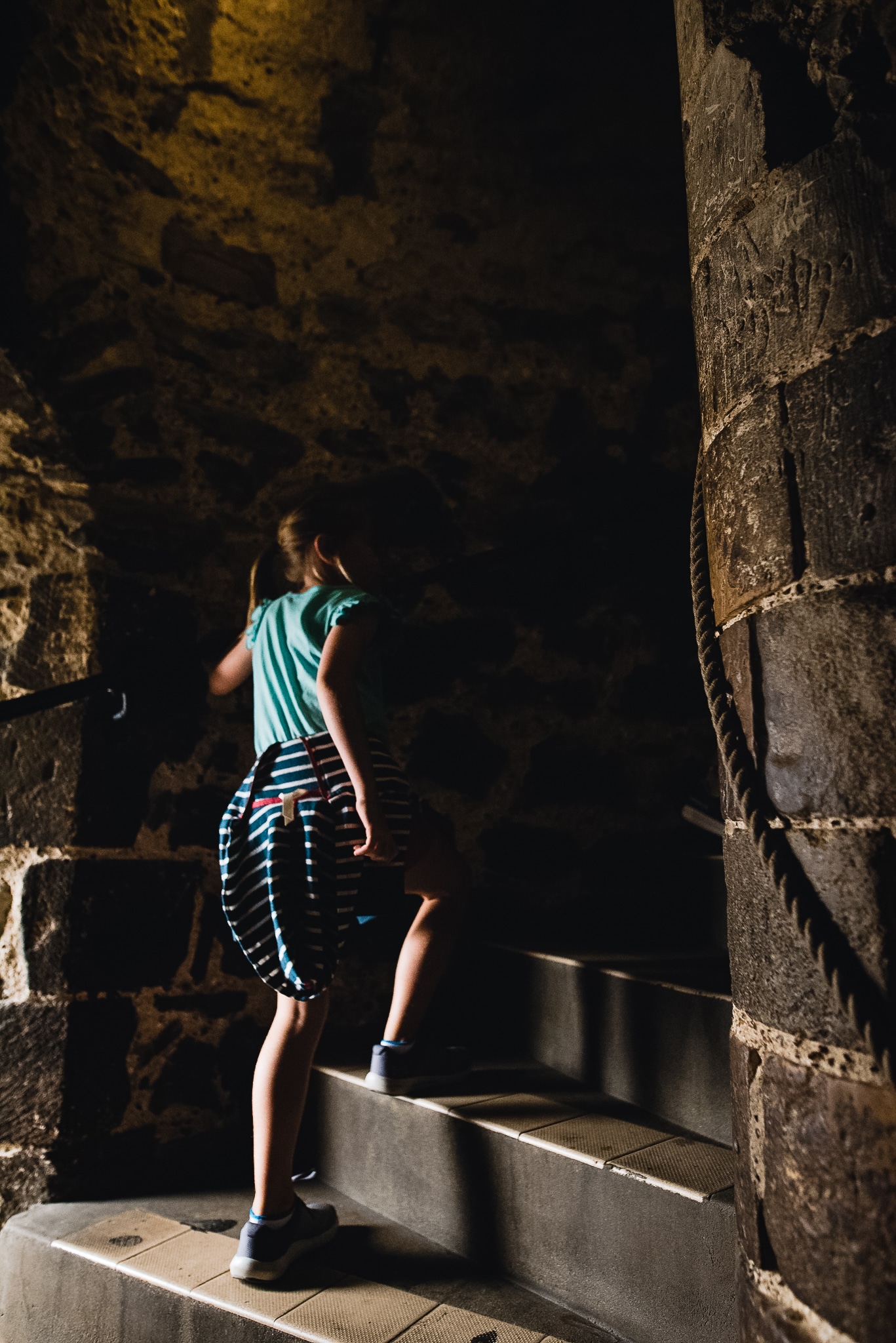 child walking up castle stairs in low light