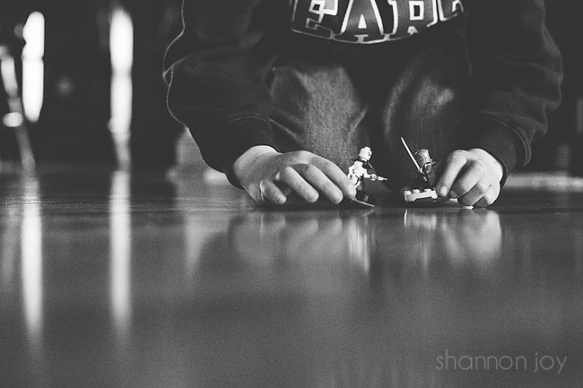 Black and white photograph of a child playing with toys.