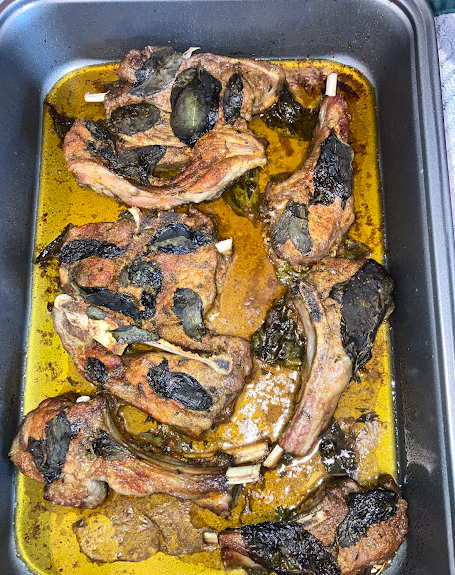cooked mint lamb chops and lamb shanks in a baking pan