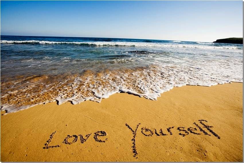 A serene beach with the words Love Yourself written in the sand, a gentle reminder to protect your peace and stay open-hearted.