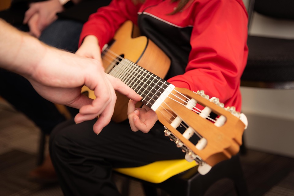 enfant qui apprend à jouer de la guitare