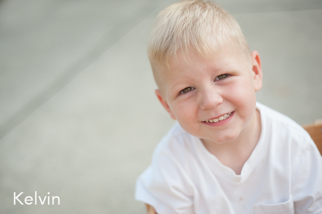 A child smiling wearing a white shirt.