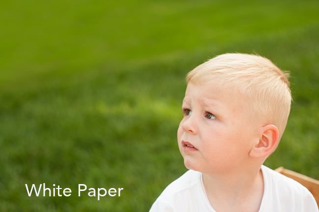 Child wearing a white shirt looking off out of the frame.