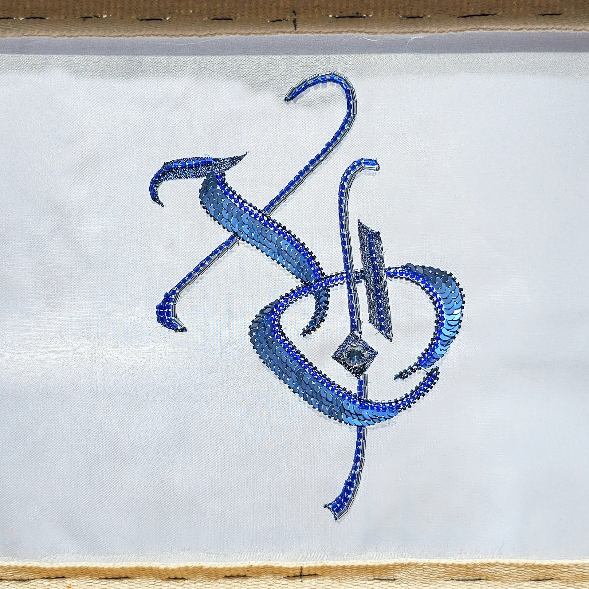 Hand-embroidered XO lettering from the Introduction to Luneville Embroidery course, worked in blue sequins, bugle beads, and crystals.