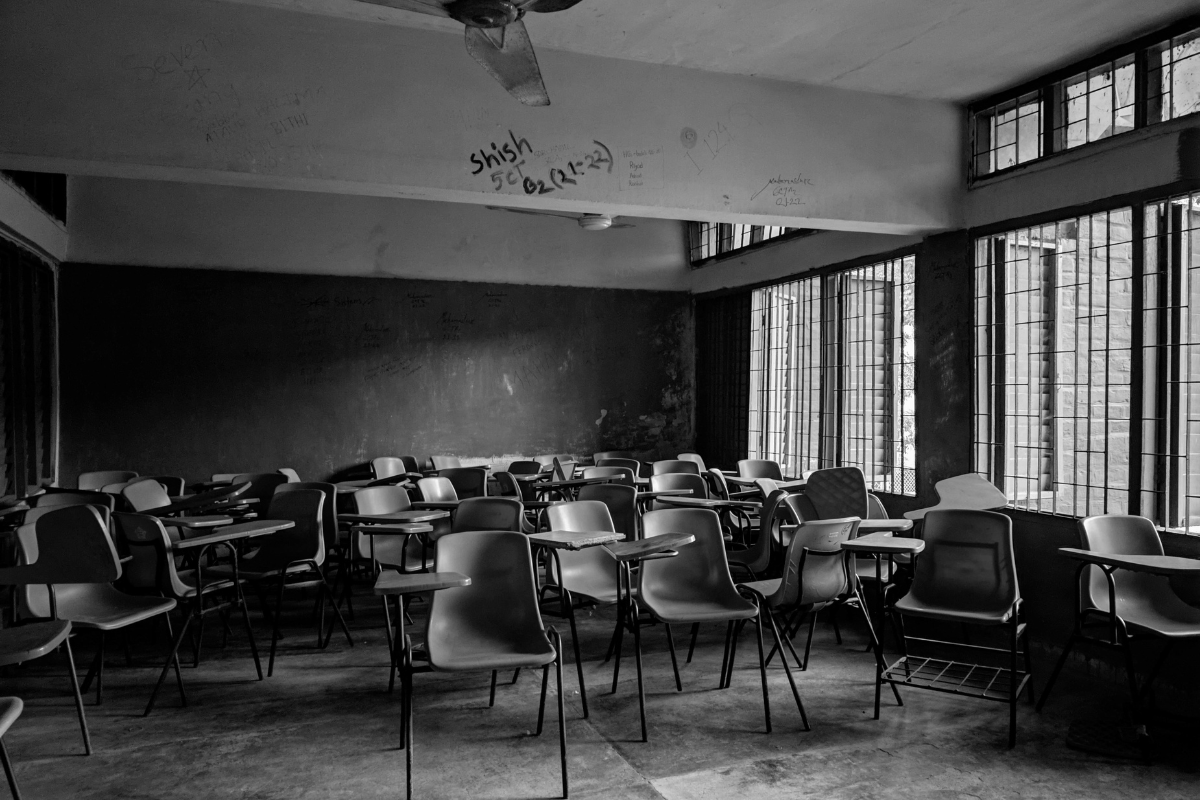 A dark classroom  with empty desks