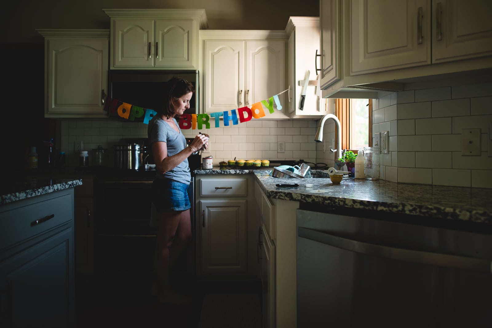 self portrait of woman in kitchen icing cupcakes