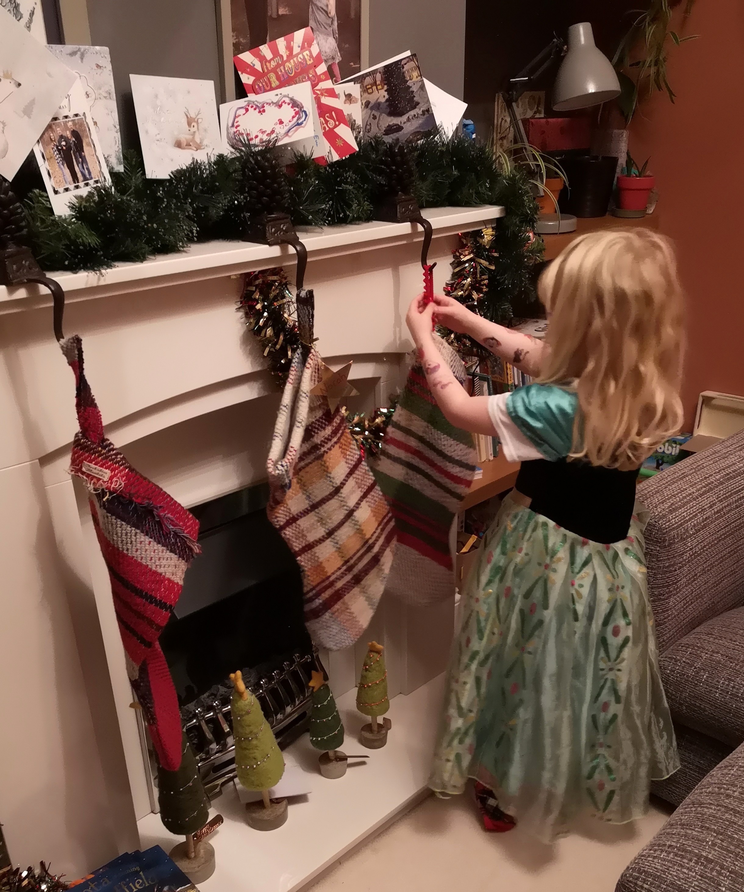 Young girl hanging Christmas stocking early