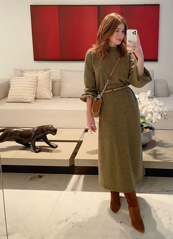  photo of Anastasia Akh. taking a full body mirror selfie, living room couch and coffee table with decor in background