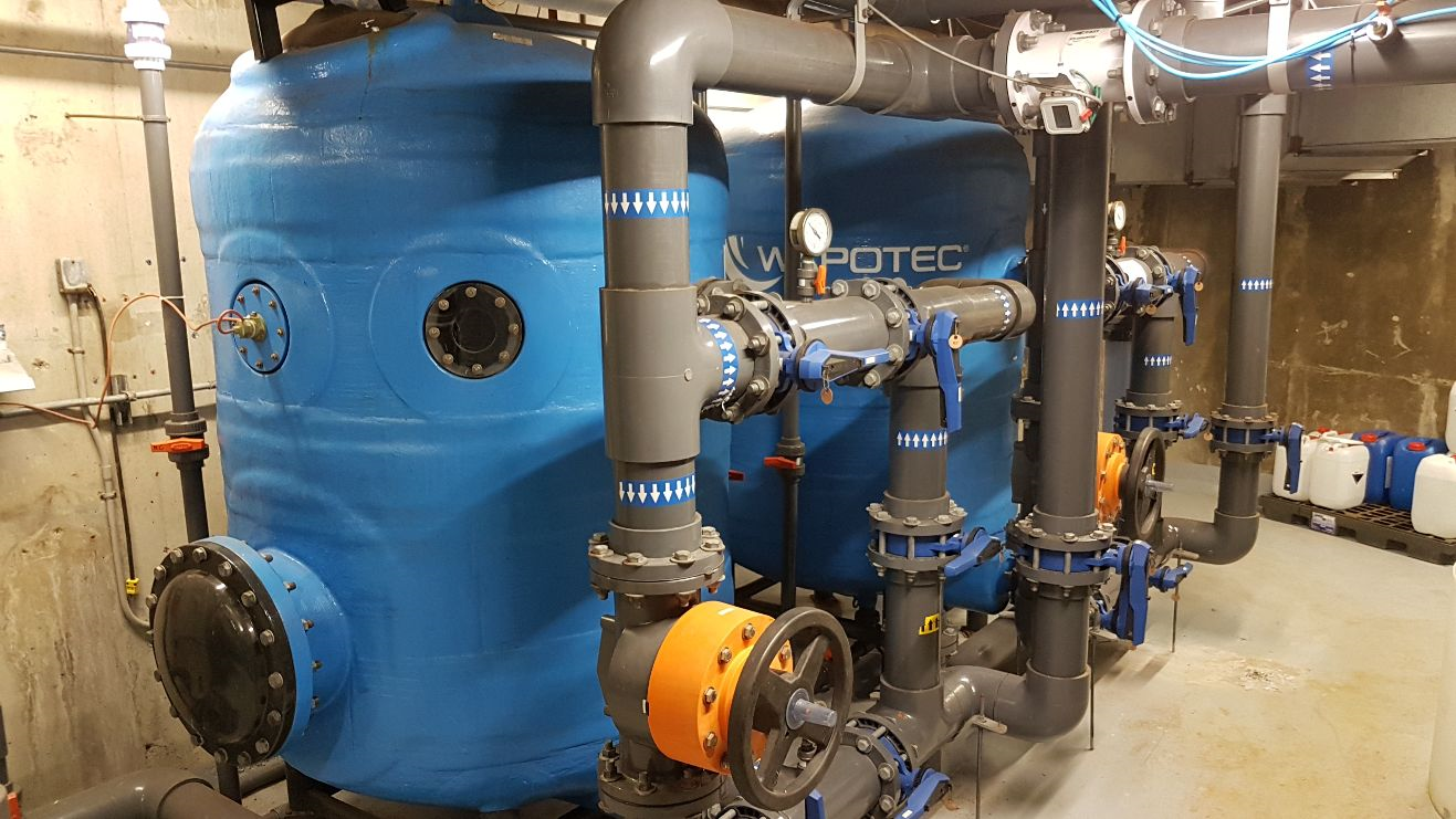Photo of a commercial pool plant room with sand filters in the foreground
