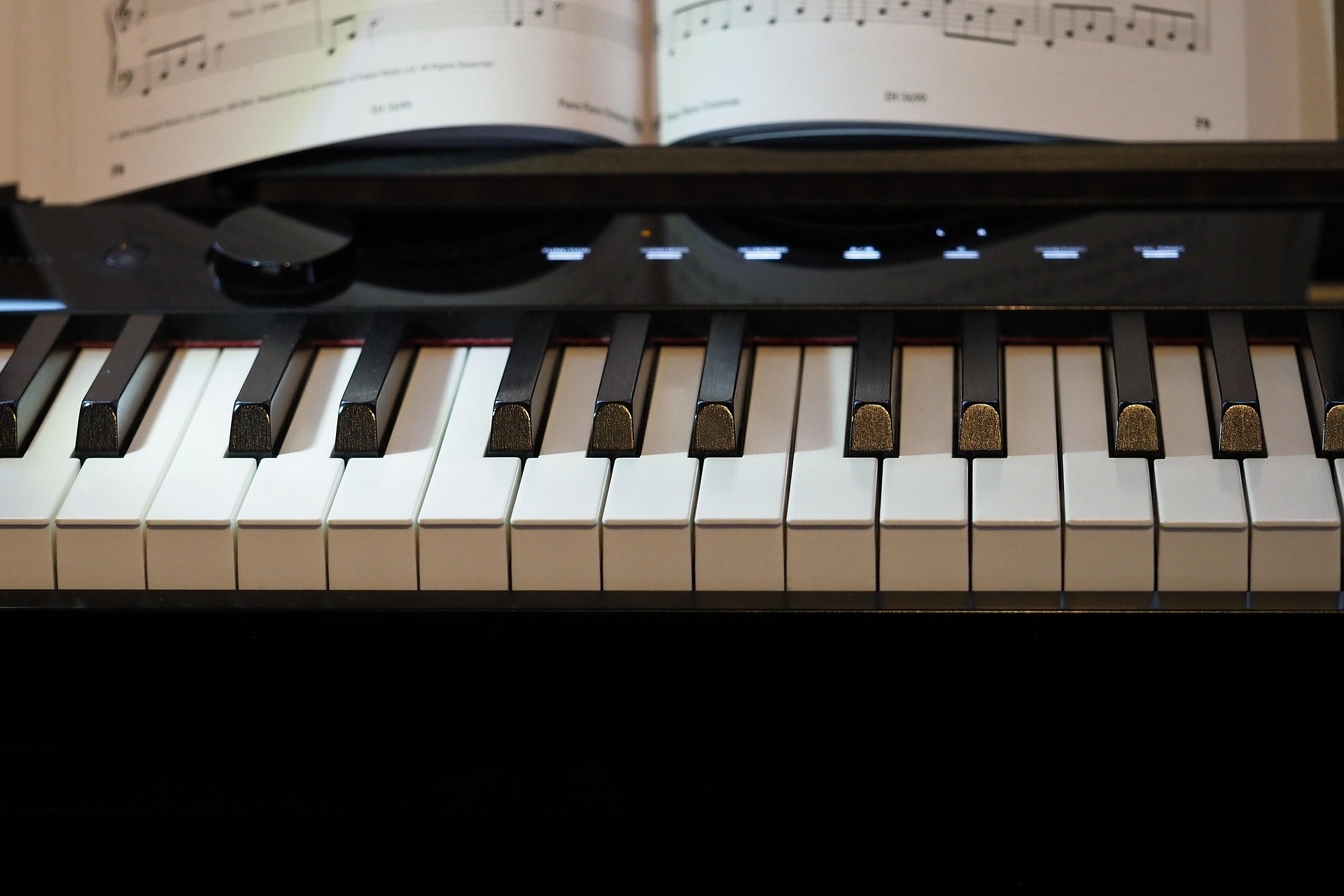 a close-up photo of a digital piano with music on the stand