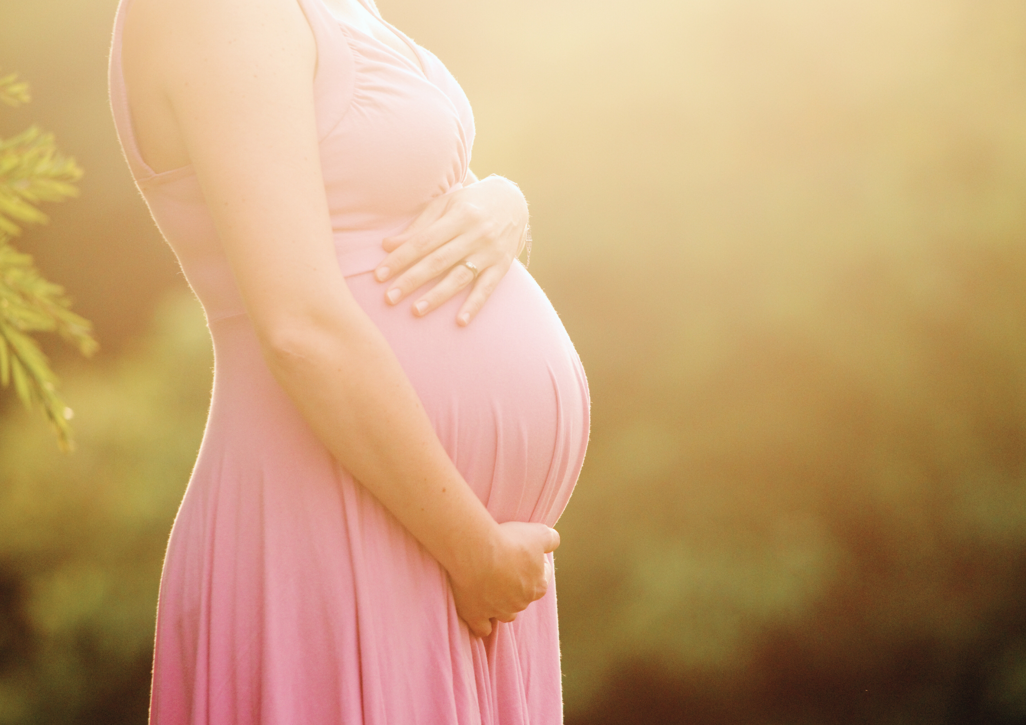 Femme enceinte tenant son ventre, symbole d'accueil de la vie et de ses cycles