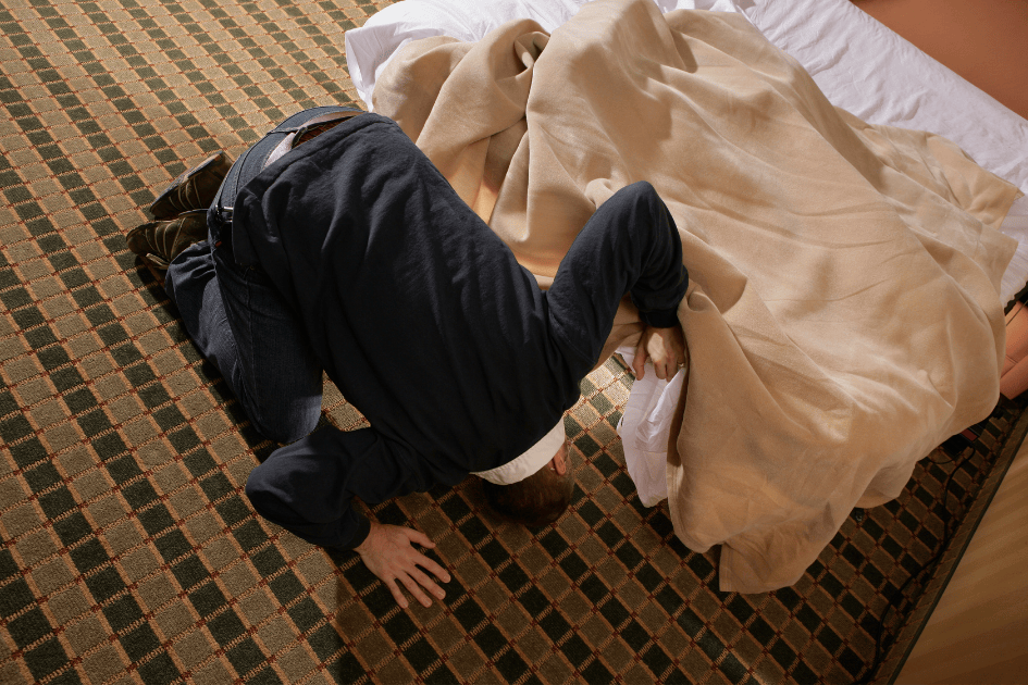 Personne qui cherche quelque chose sous son lit