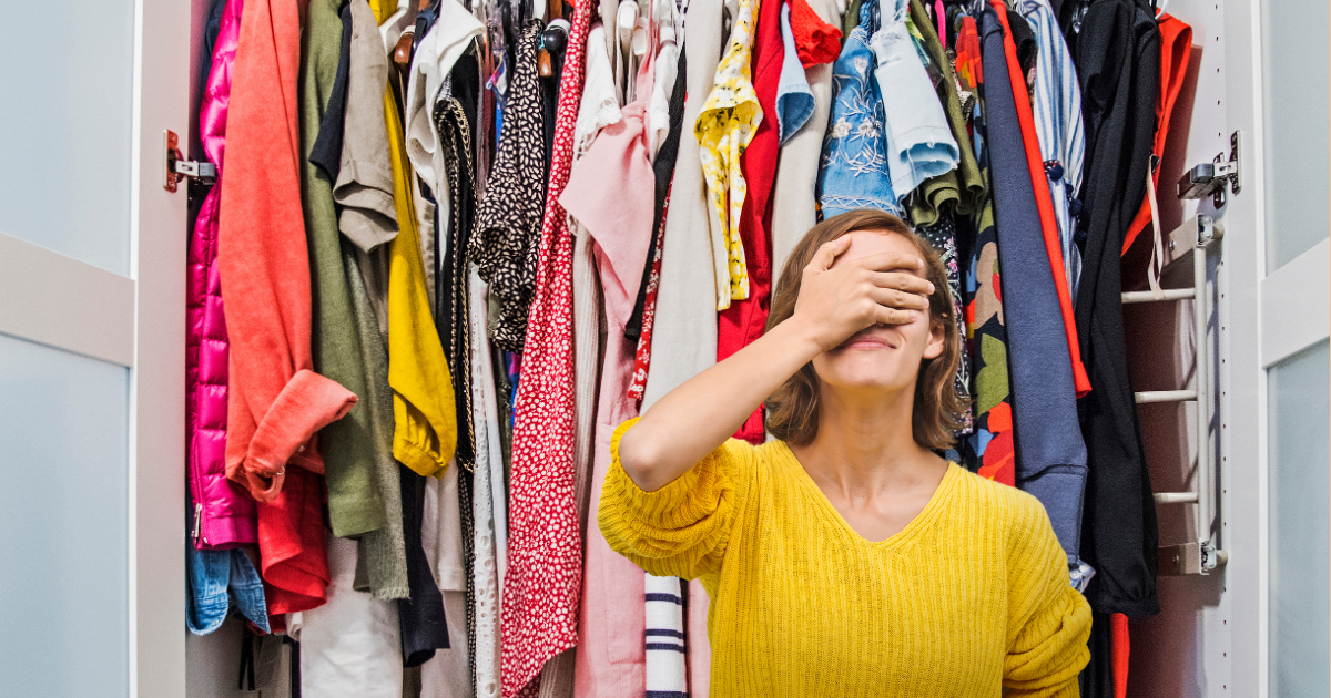 Femme qui se tient la tête devant un dressing bondé