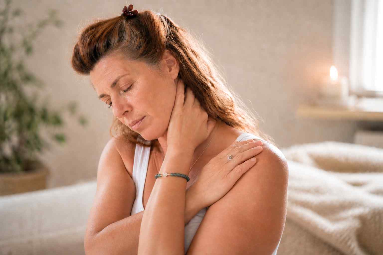 Vrouw in Do-In Yoga houding om spanning in nek en schouders te verlichten bij overprikkeling