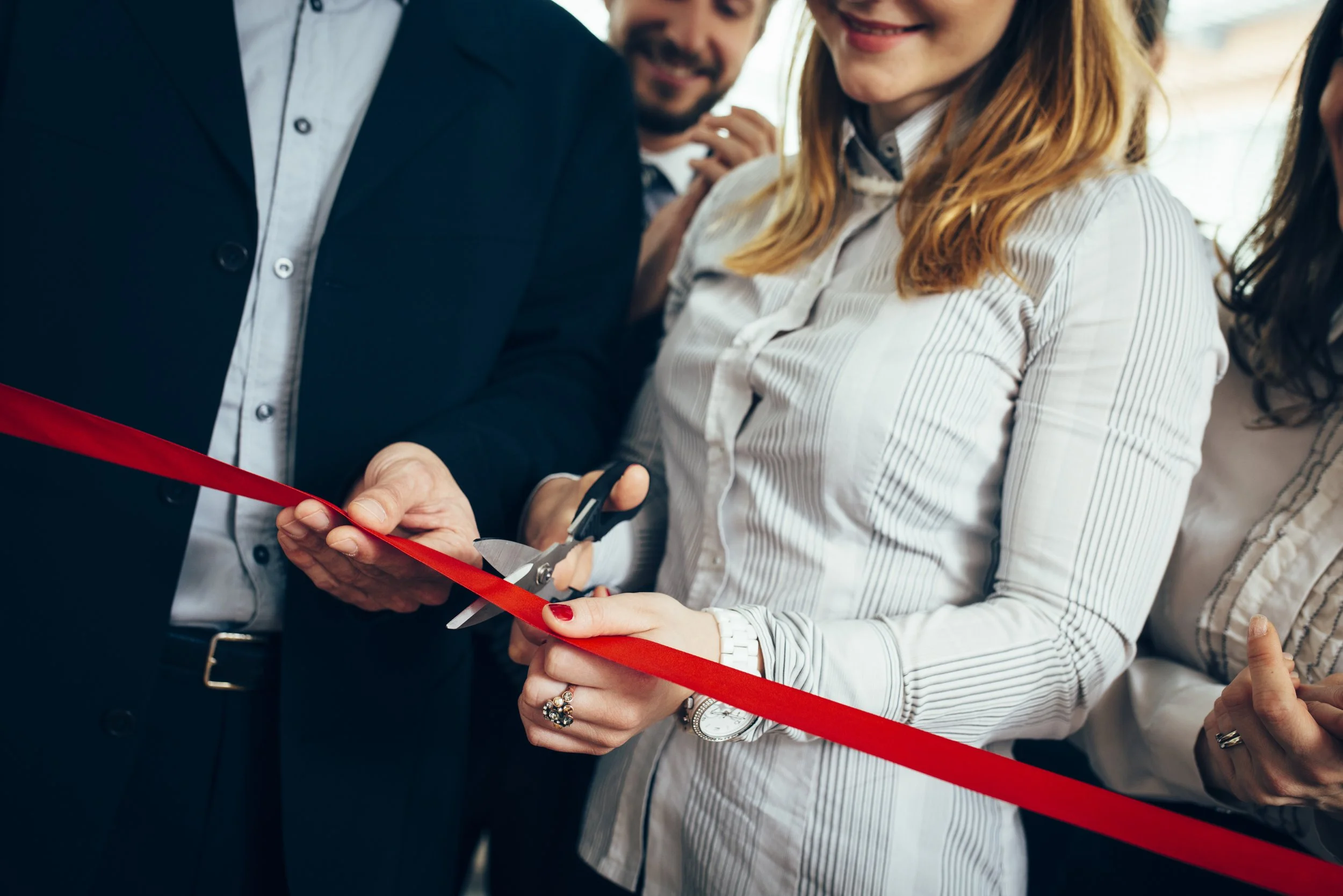 2 people performing a ribbon cutting