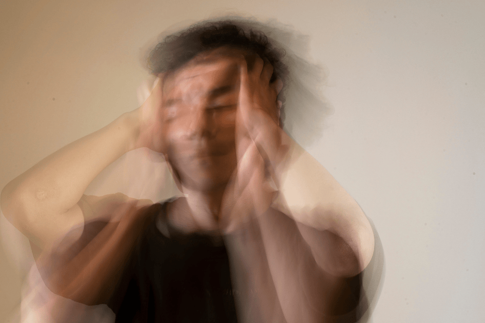 Personne floue qui se tient la tête et semble souffrir