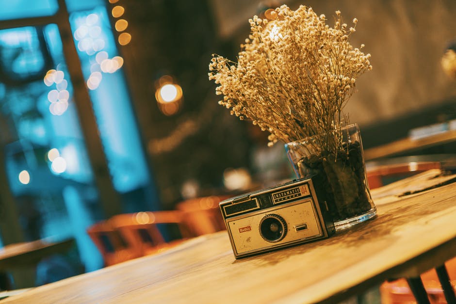a vase with dry flowers and an old radio on the table
