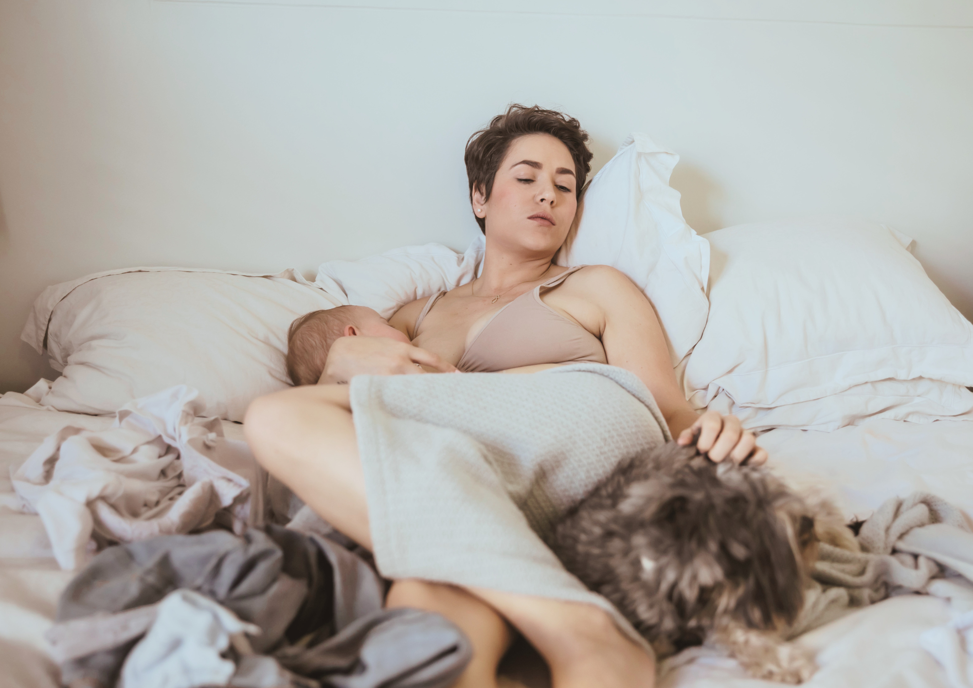 Une femme pensive, allongée avec son bébé