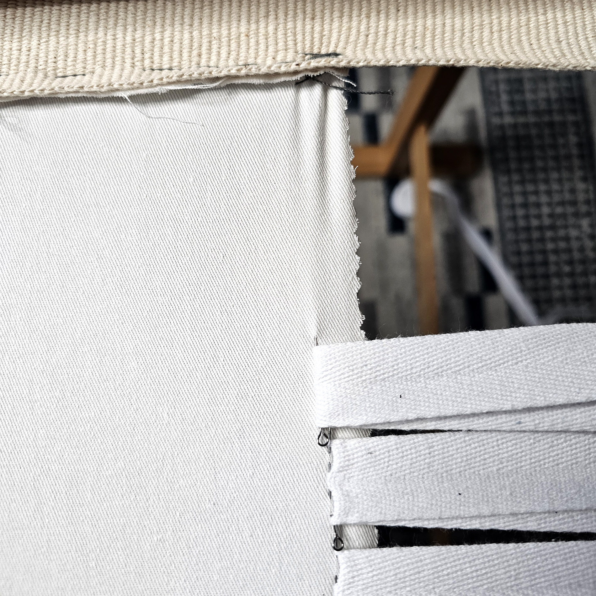 Pin the tape 1 cm back from the edge of the fabric, pulling it tight as you go.