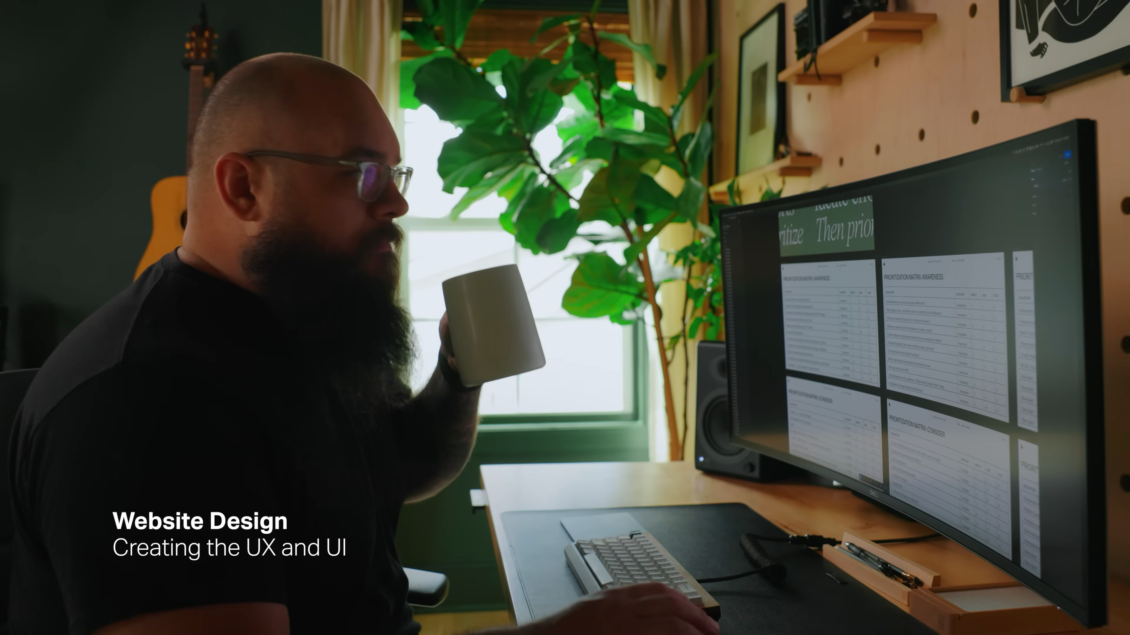 Designer working on website UX and UI design for Mode’s rebrand, reviewing layouts on a large monitor, from Matthew Encina’s branding process video.