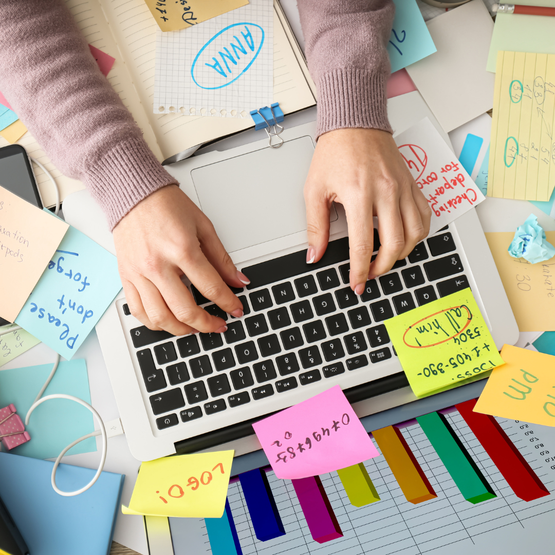 person on a laptop with post it notes everywhere