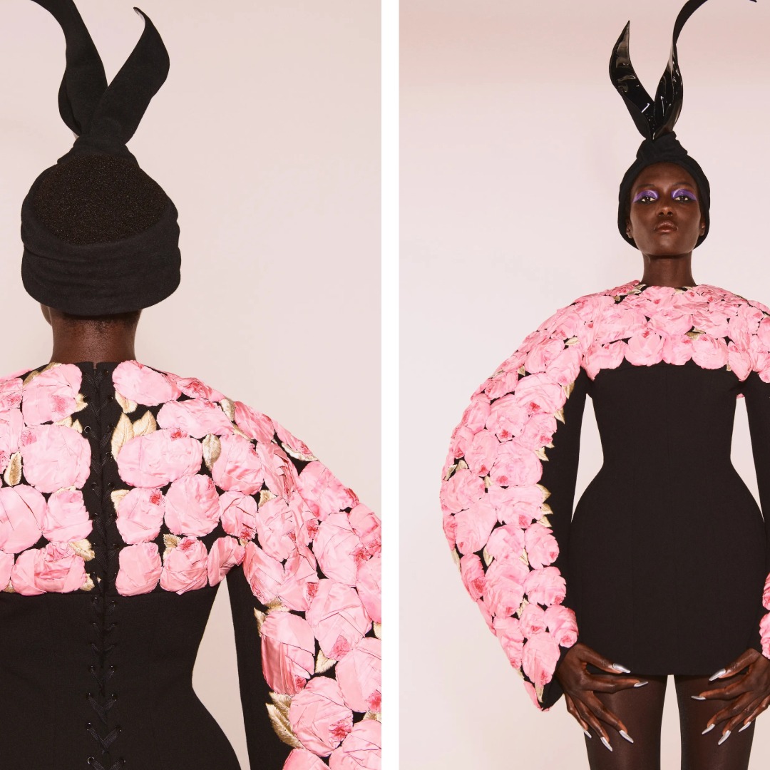Schiaparelli Fall 2021 Couture black garment with pink roses covering the shoulders and sleeves, referencing the 1937 Cocteau rose coat.