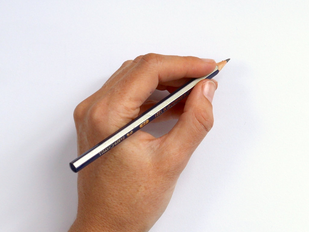hand holding a pencil in a standard tripod grip