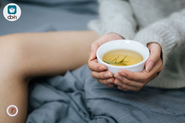 Vrouw geniet van Yin-voedende thee als zelfzorg bij opvliegers