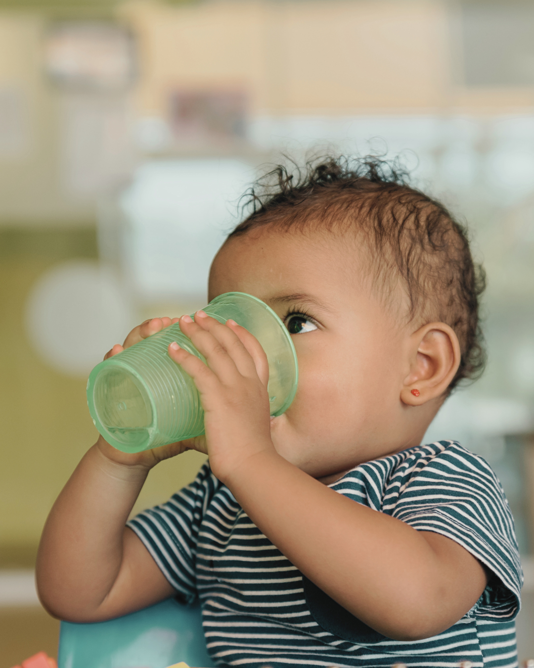 Toddler drinking from an open cup to support oral motor development and healthy swallowing habits