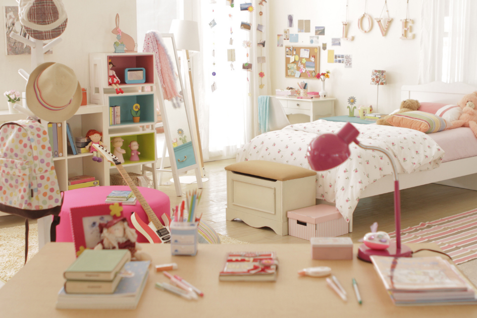 Bureau d’enfant avec livres, stylos et lampe dans une chambre lumineuse, illustrant un espace dédié pour dessiner, créer et faire ses devoirs.
