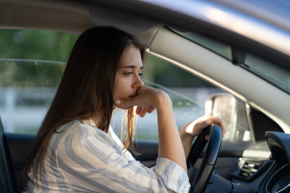 femme pensive au volant de sa voiture à l'arrêt