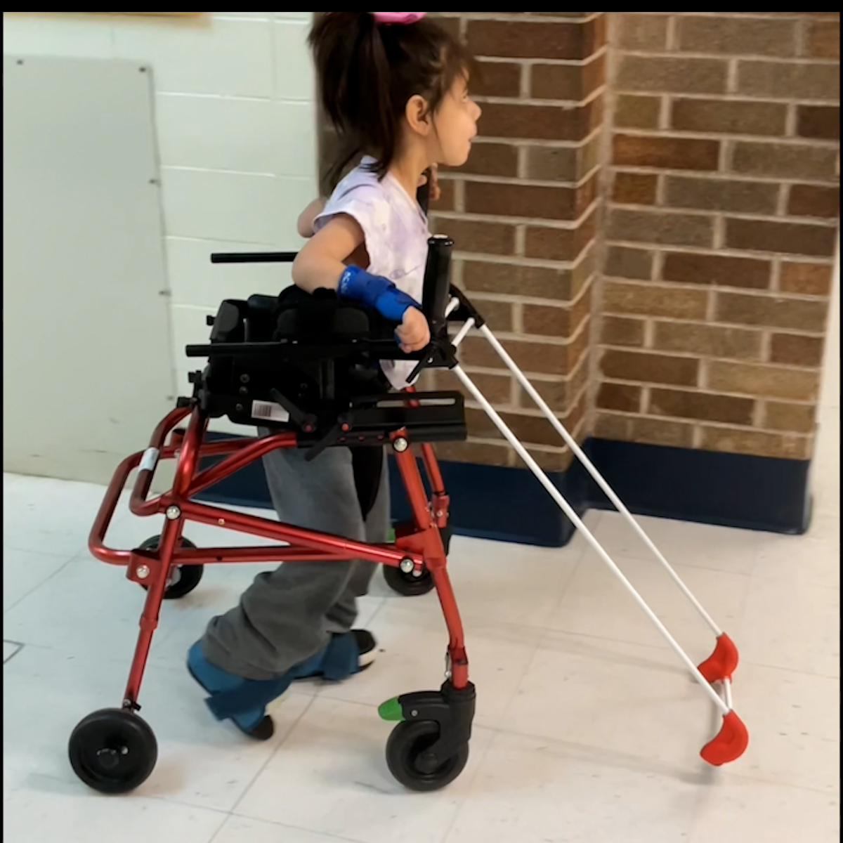 5-year-old girl in a gait trainer is wearing a specialty frame