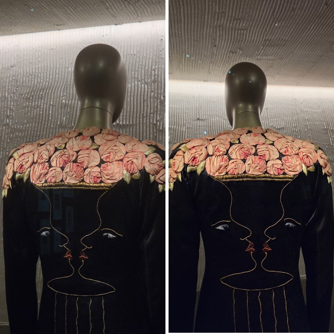 Back view of Schiaparelli’s 1937 rose evening coat with pink roses, gold embroidered profile faces and a vase-like double image.