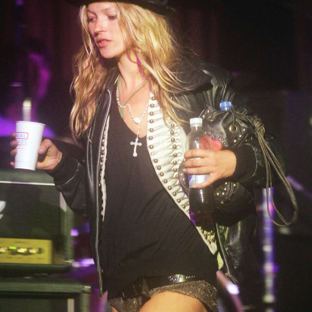 Kate Moss at Glastonbury Festival in 2005 wearing a cream military-style jacket with decorative braid and buttons under a black leather jacket. Photograph by MJ Kim/Getty Images.