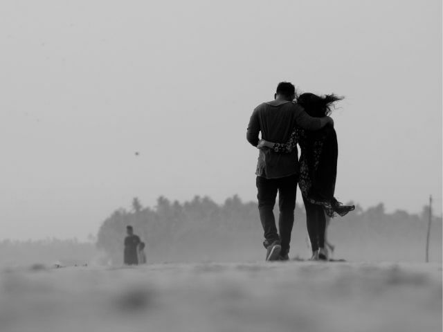 femme qui marche sur la plage avec un homme qu'elle aime 