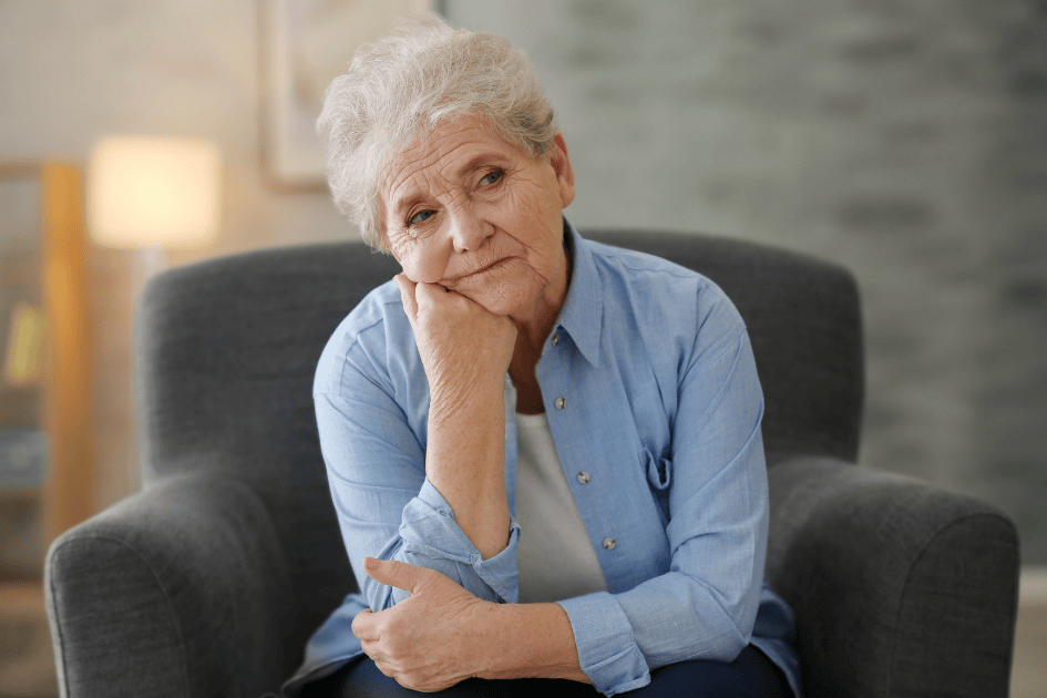 Femme senior assise dans un fauteuil, réfléchissant à son avenir chez elle et à la façon de continuer à bien vivre chez soi plus longtemps