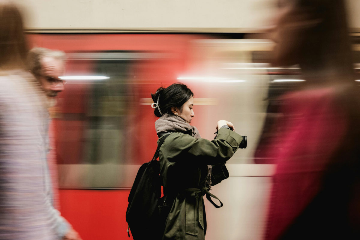A photo of a woman in front of blurred subway